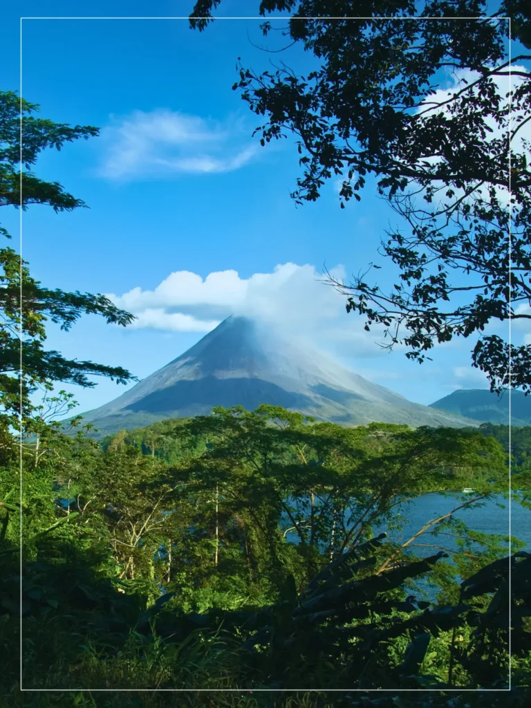 Arenal Volcano viewed from rainforest with lake in the foreground, Costa Rica.