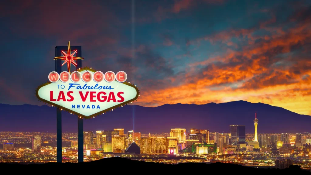 Welcome to Las Vegas sign with city skyline and mountains at sunset in Nevada, United States.