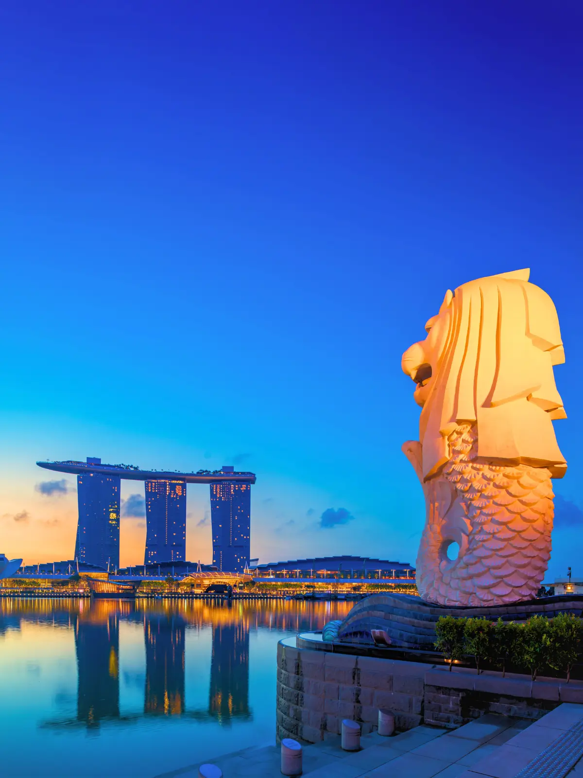 Merlion statue overlooking Marina Bay with Marina Bay Sands skyline in Singapore.