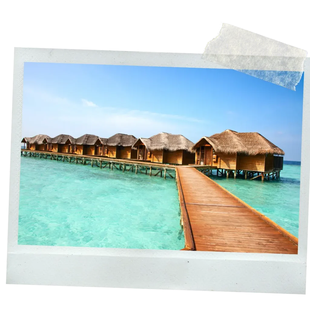 Overwater villas connected by a wooden boardwalk in Maldives.
