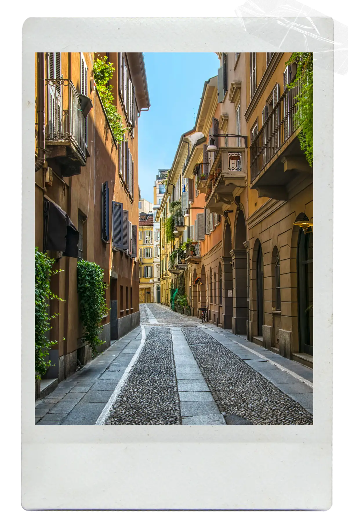 Quiet cobblestone street lined with historic buildings in an Italian city.