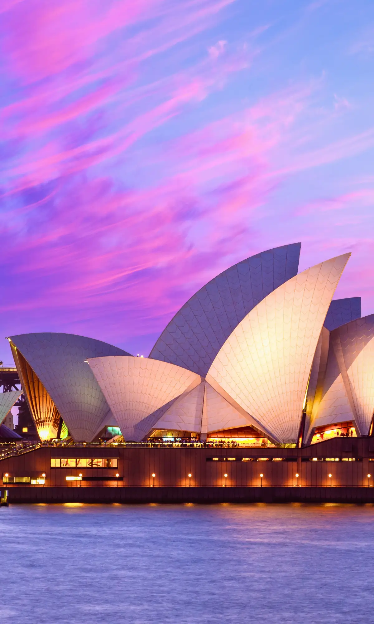 Sydney Opera House at sunset with pink and purple sky over Sydney Harbour, Australia.
