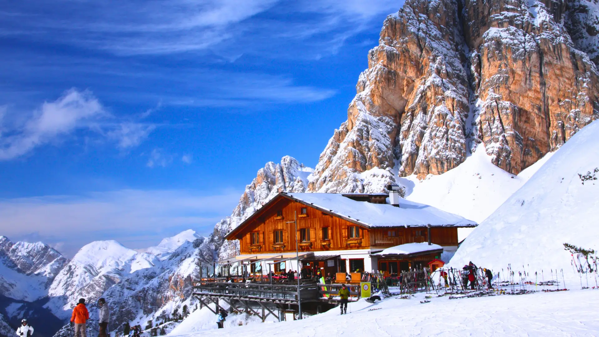 Mountain hut on snowy slopes in Cortina d’Ampezzo with the Dolomites.