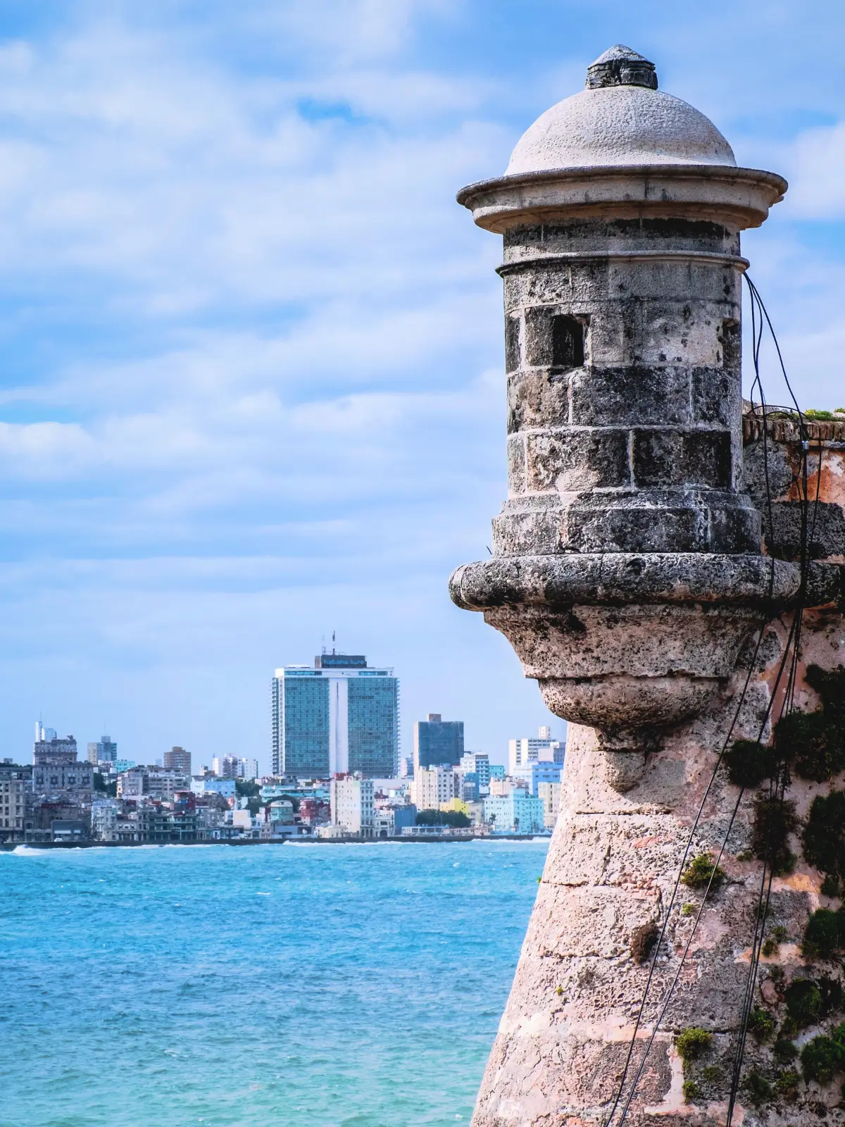 View of the El Morro fortress sentry tower in Havana with the city skyline.