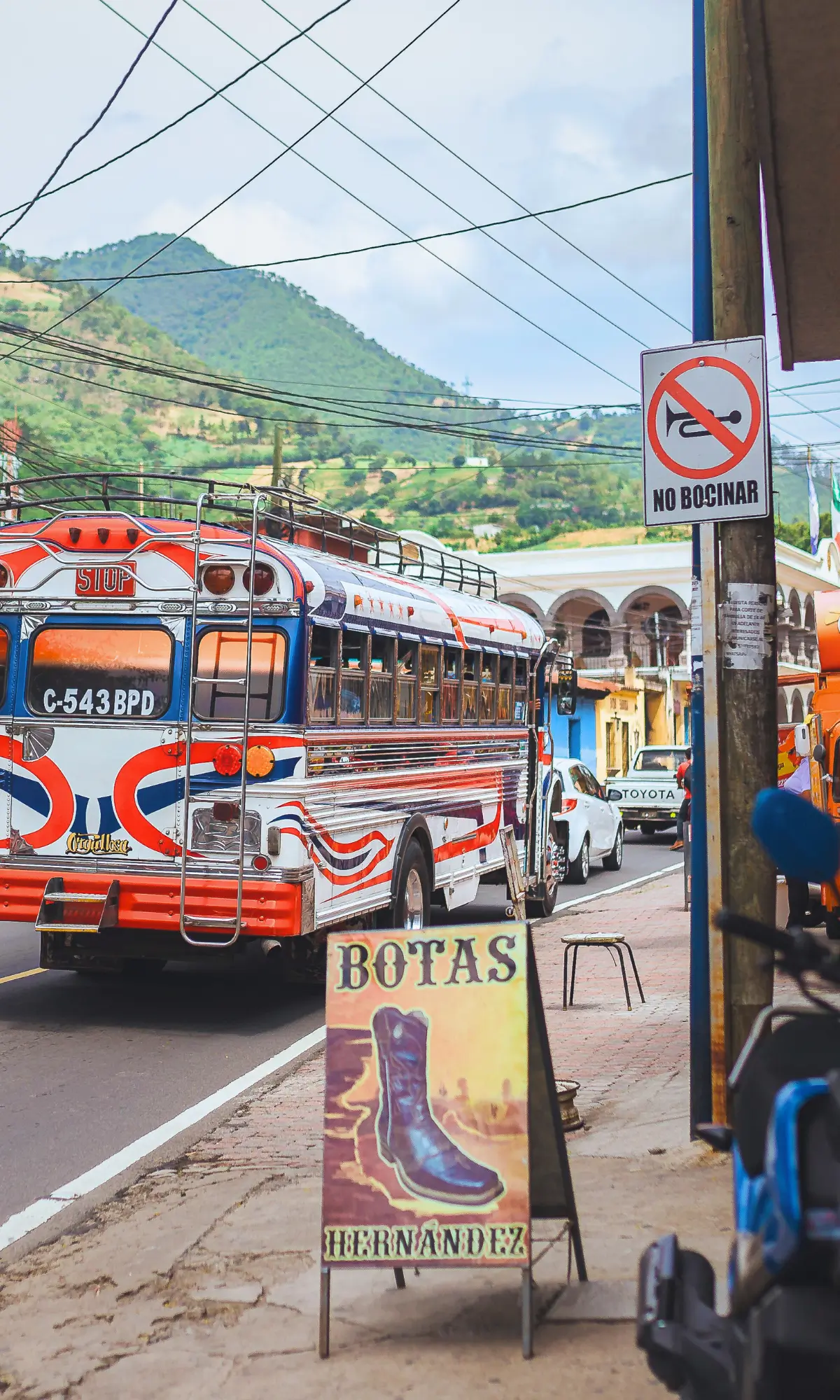 Colourful chicken bus driving through a Guatemalan town.