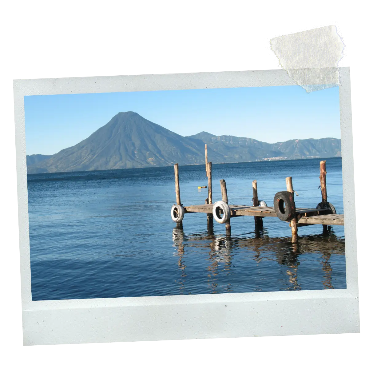 Wooden pier on Lake Atitlán with volcanoes rising in the background.