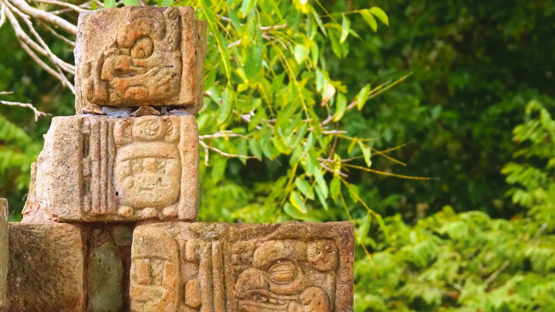 Ancient Maya stone carvings surrounded by greenery in Copán, Honduras.