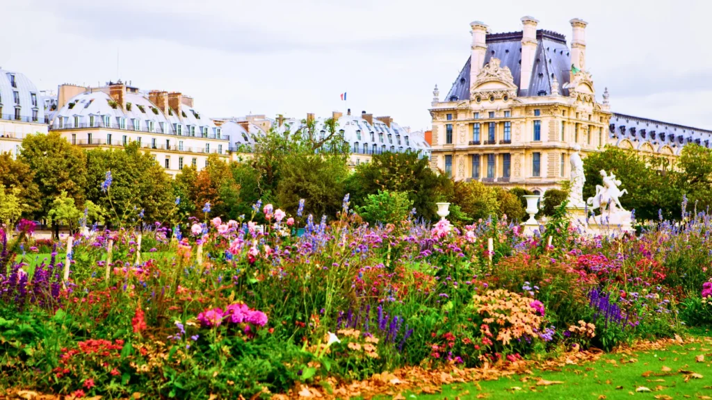 Romantic park in Paris with colourful flowers and historic buildings in the background.