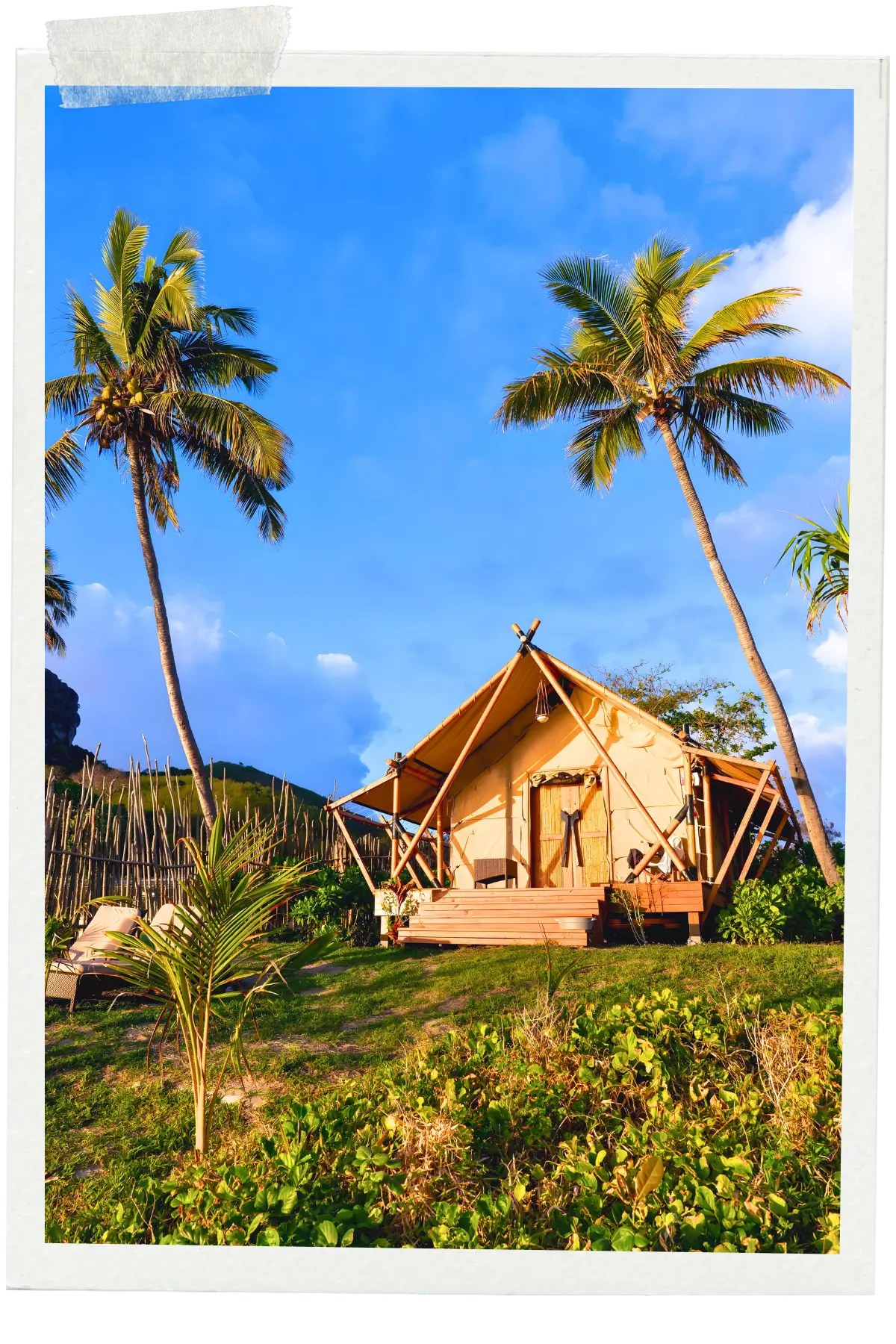 Eco-style tent lodge surrounded by palm trees and tropical greenery in Fiji.