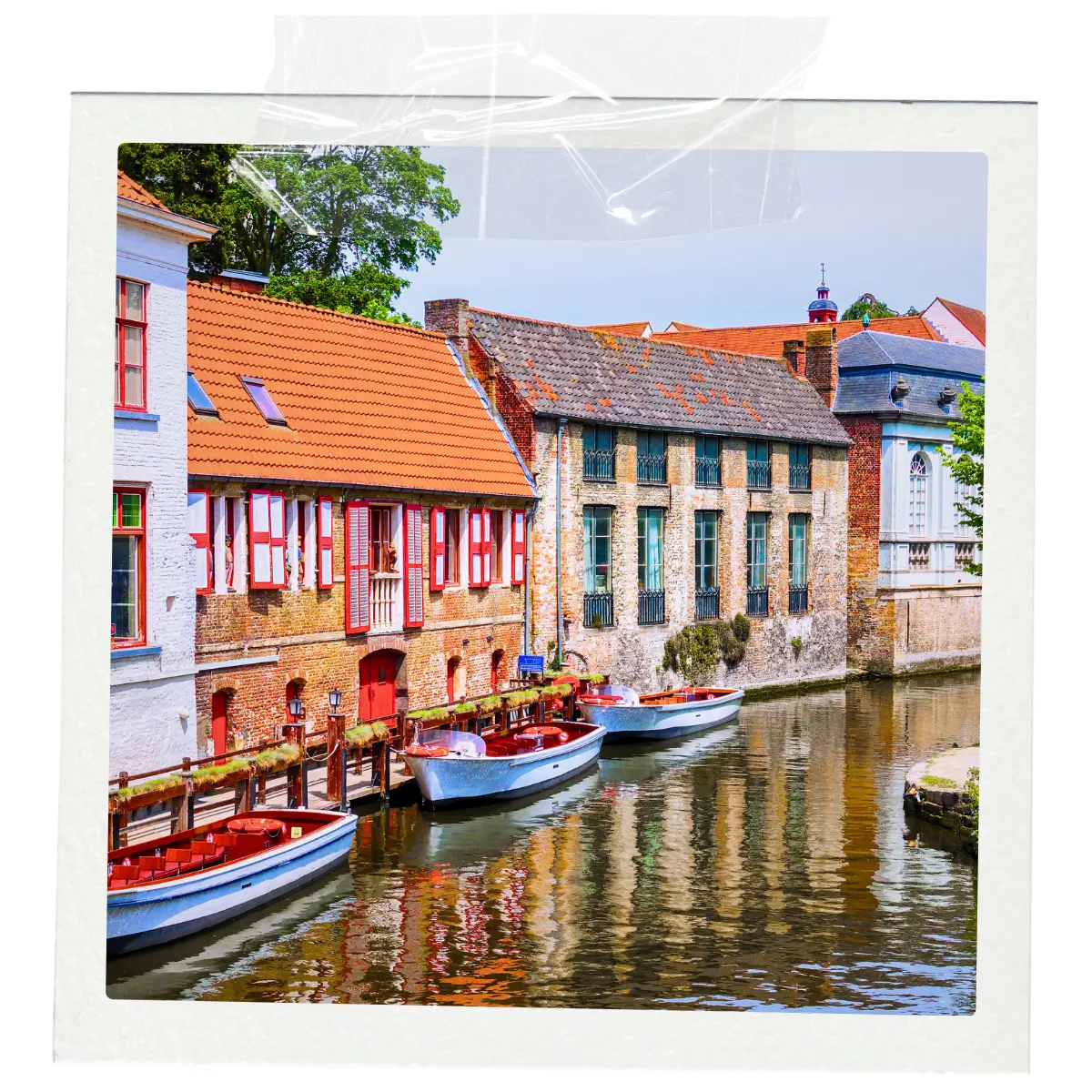 Colourful historic houses and small boats along a canal in Bruges.