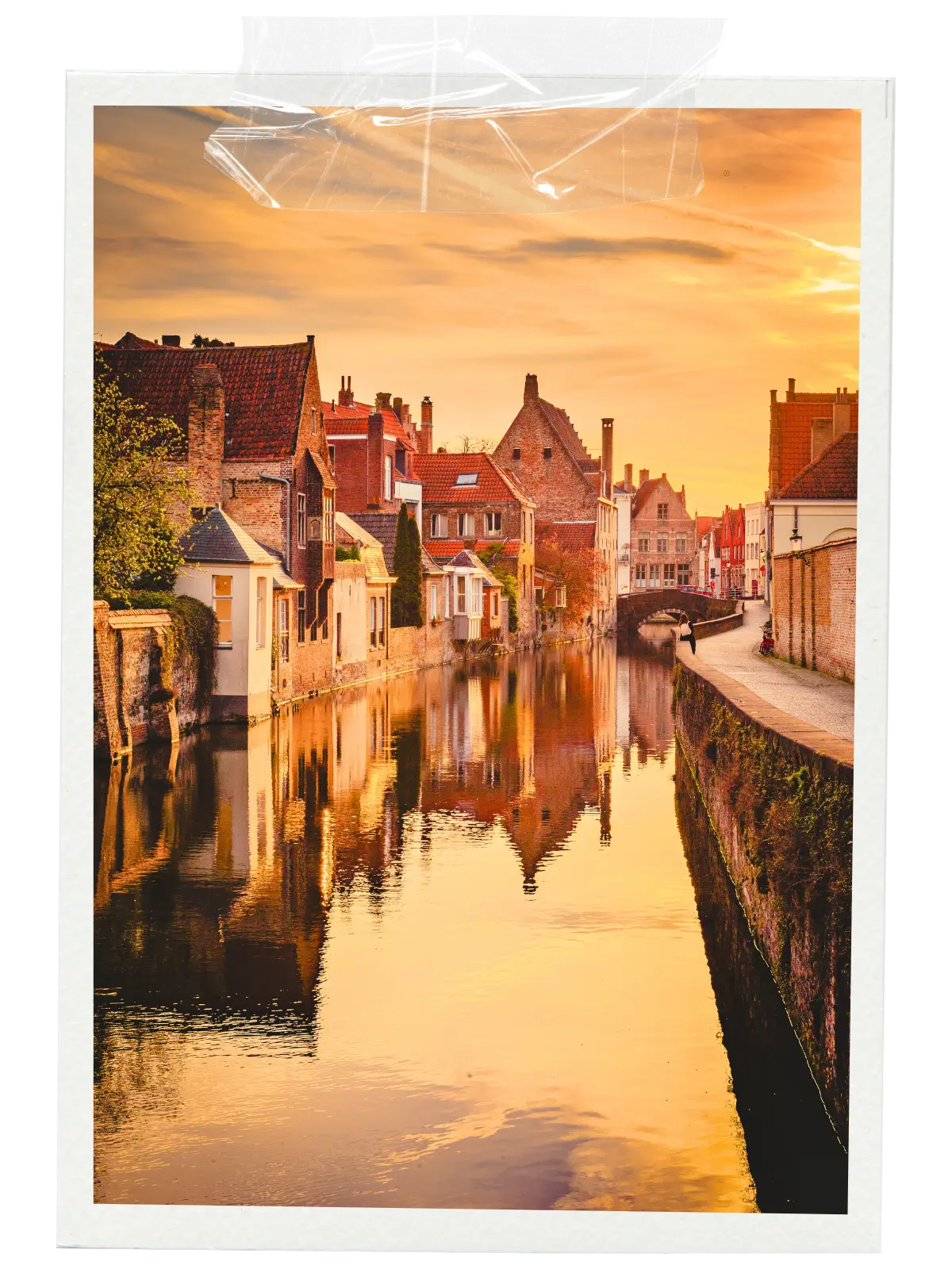 Sunset reflecting on a quiet canal lined with historic houses in Bruges.