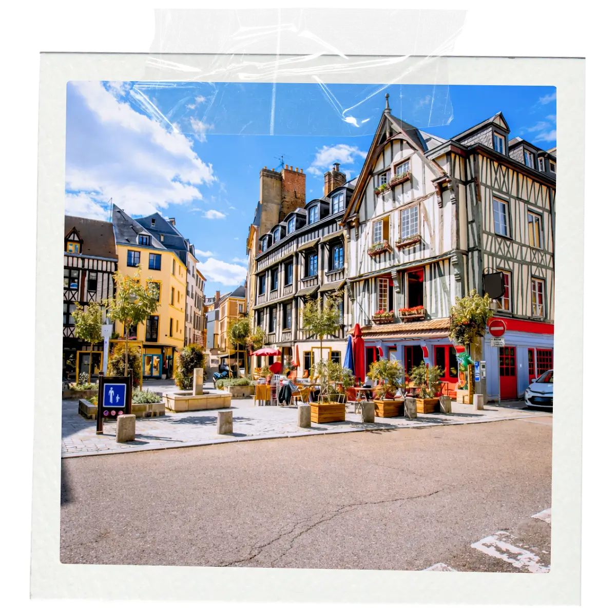 Colourful half-timbered buildings and outdoor cafés in a historic French town square.