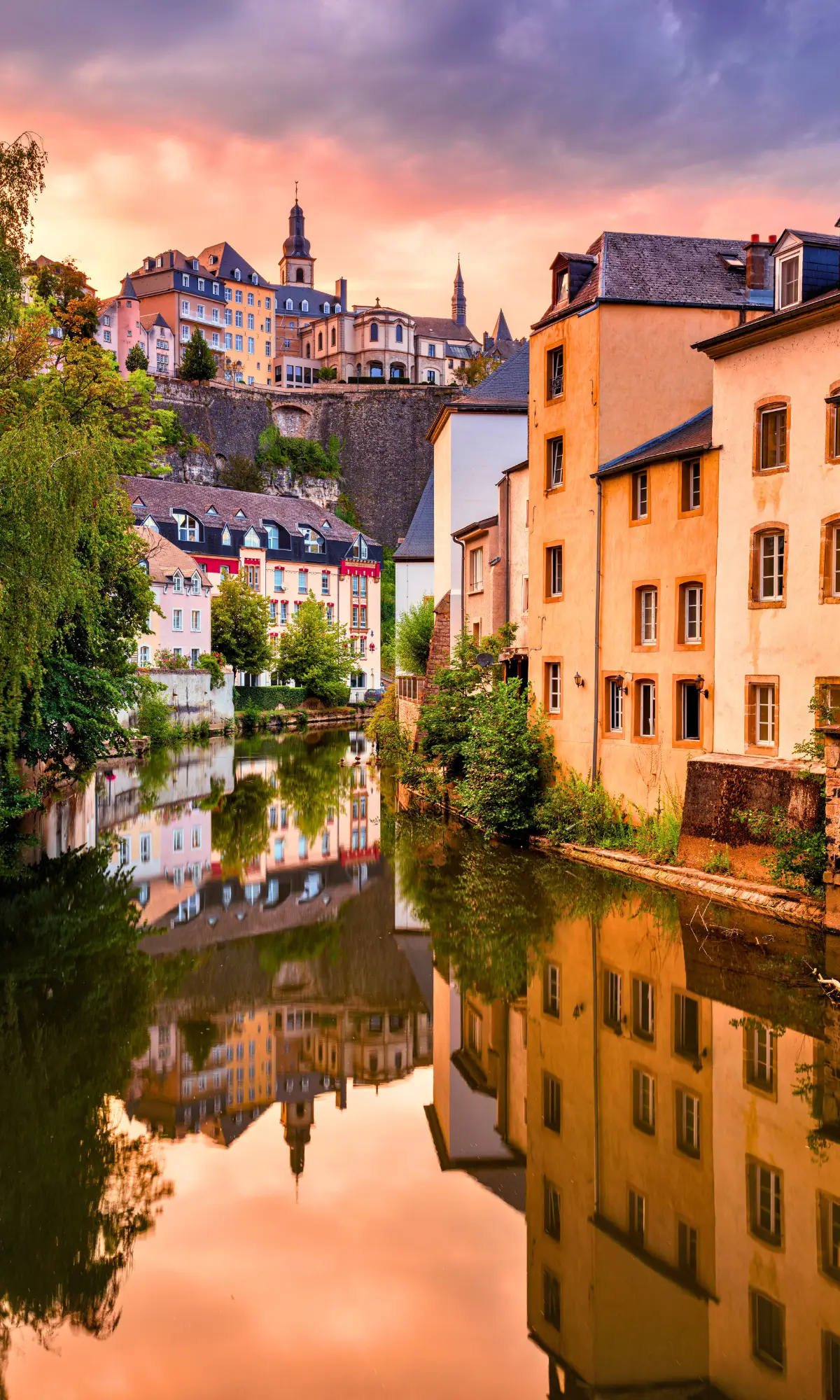 Colourful houses along the river with reflections at sunset in Luxembourg old town.