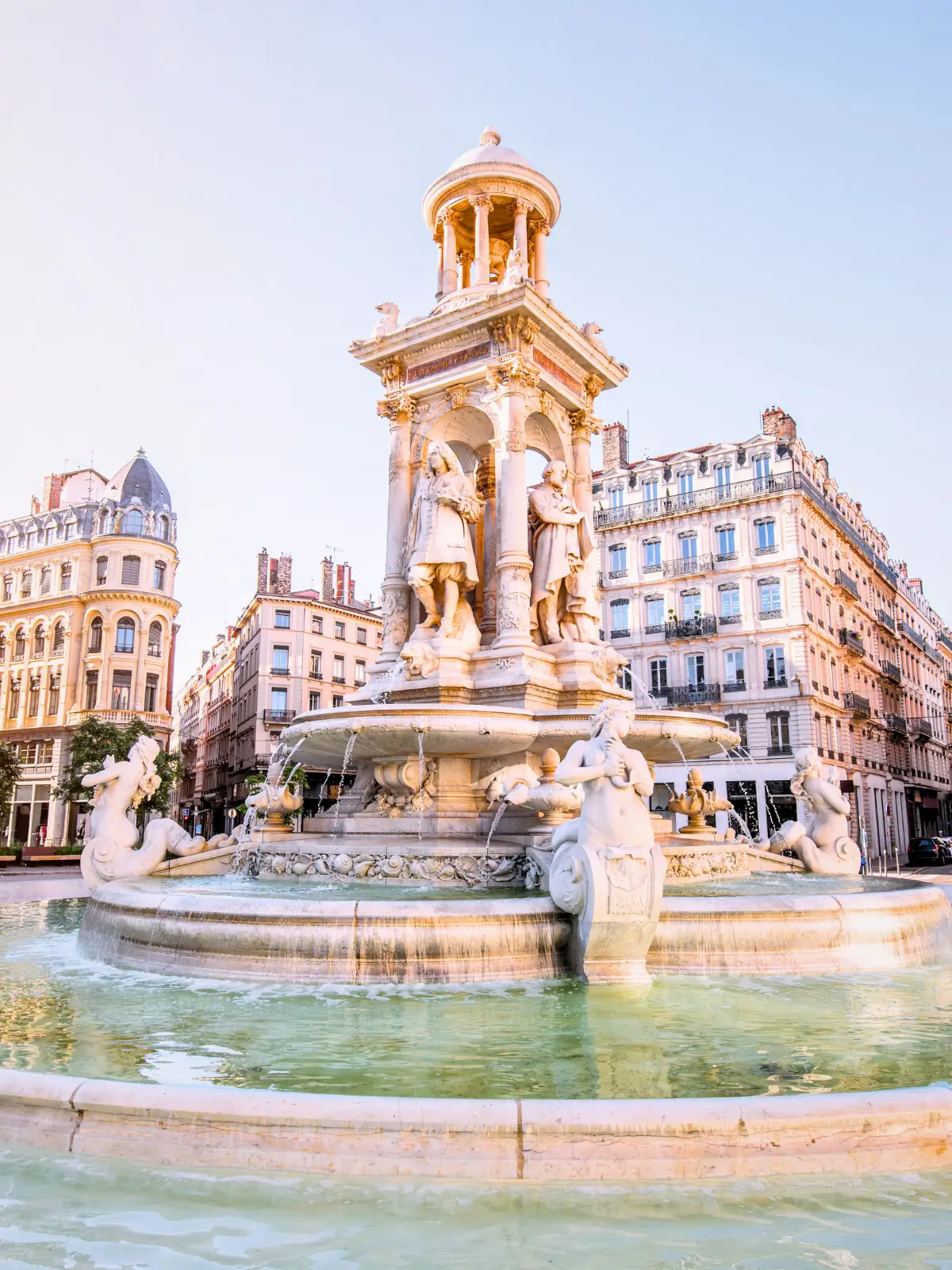 Fountain at Place des Terreaux in Lyon with historic buildings in the background.