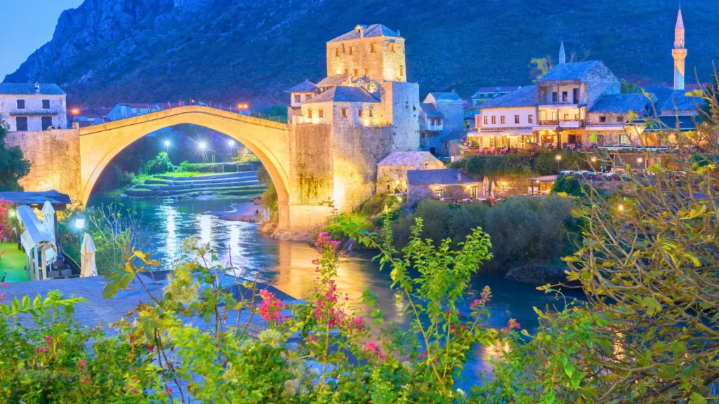 Stari Most bridge illuminated at night over the Neretva River in Mostar.