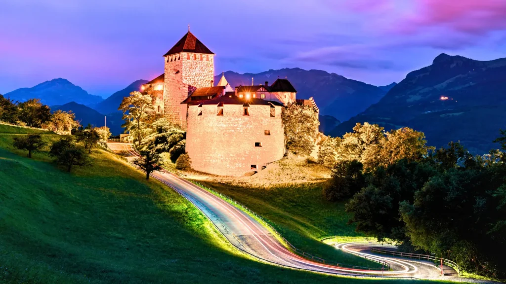 Vaduz Castle illuminated at night above the valley in Liechtenstein.