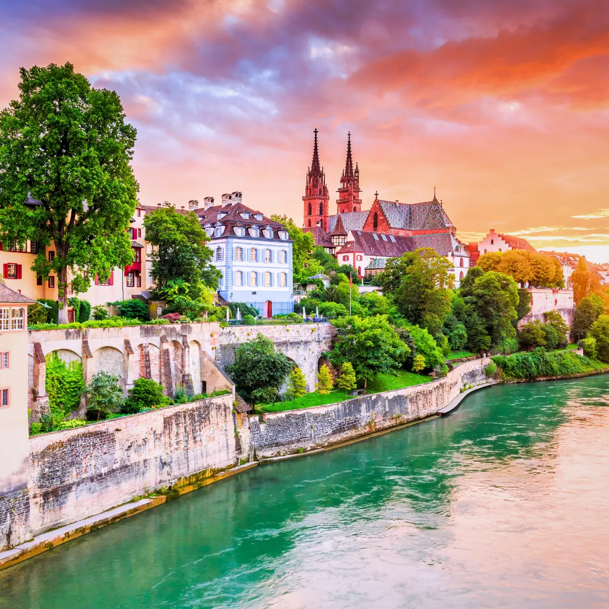 Basel Old Town along the Rhine River with historic buildings and Basel Minster in the background.