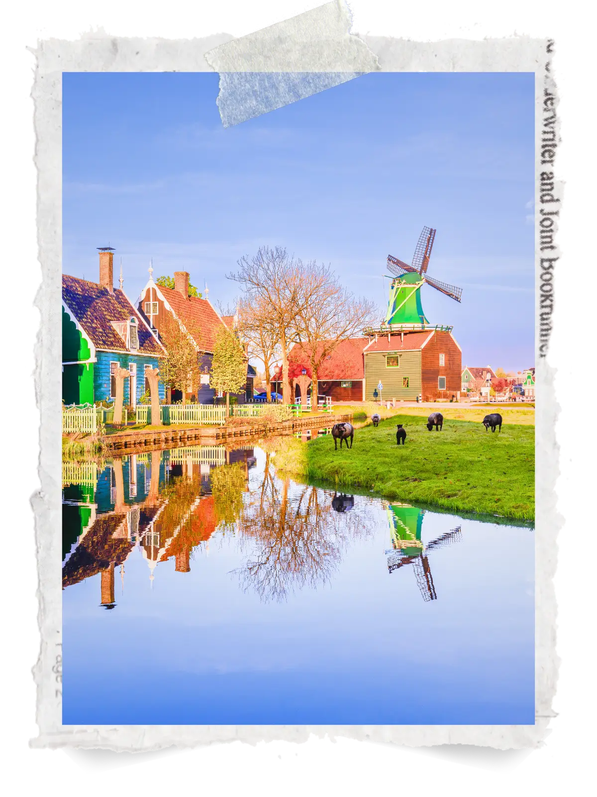 Traditional Dutch houses and a windmill beside a canal with reflections in the water.