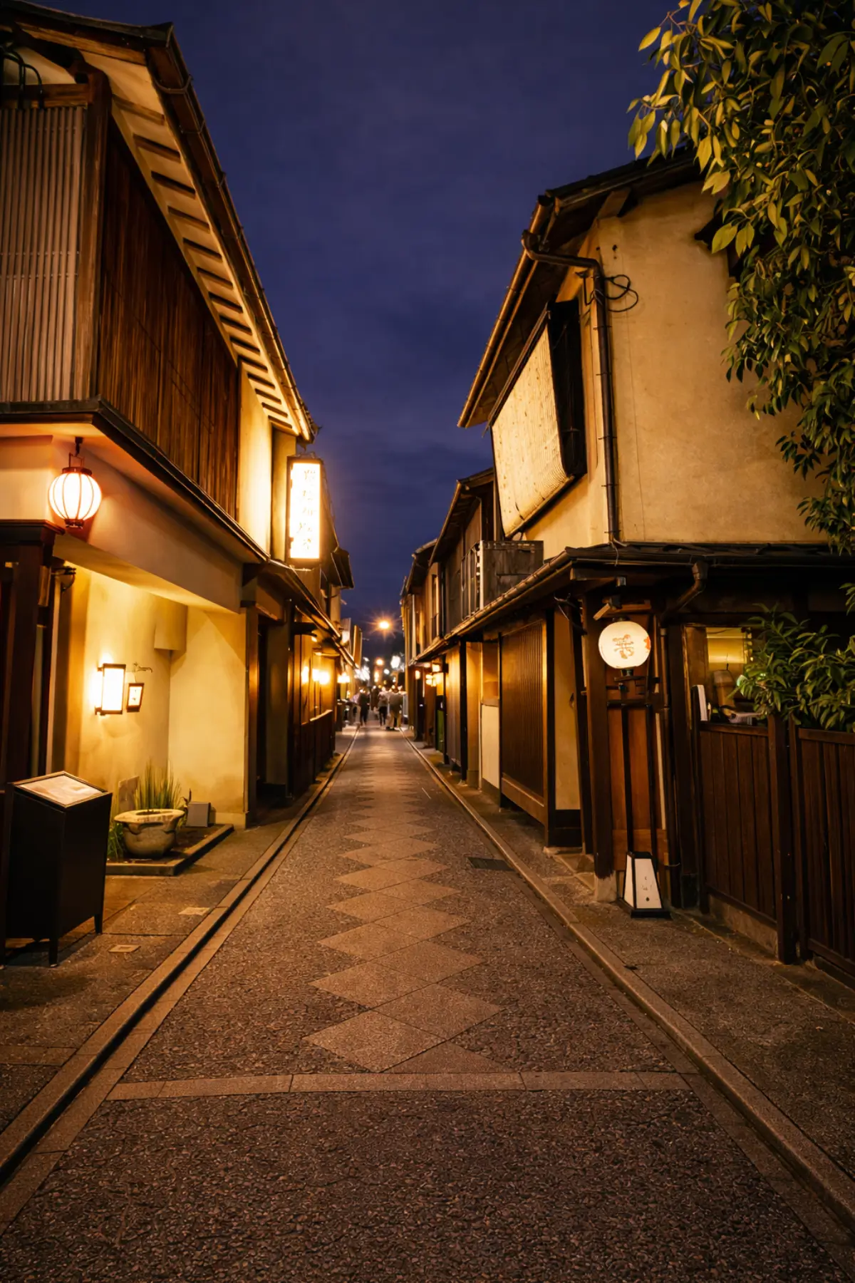 Night street in Gion with traditional buildings and lanterns.