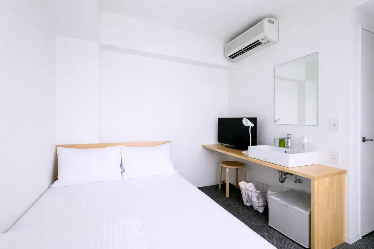 Minimalist room interior at Imu Hotel Kyoto with wooden furniture.
