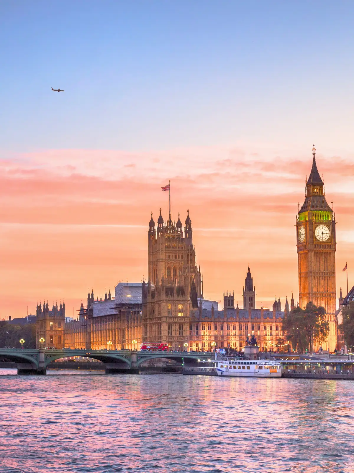 Houses of Parliament and Big Ben along the River Thames at sunset in London.