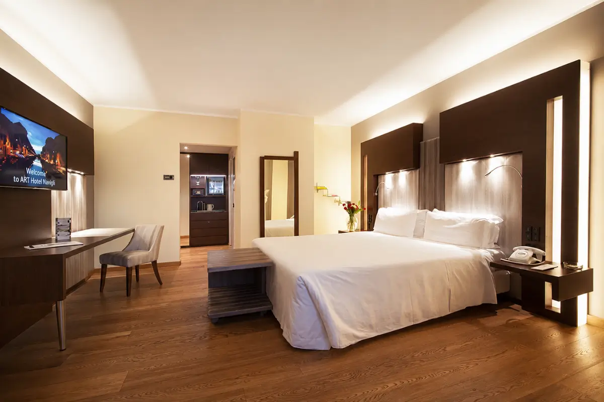 Spacious room at ART Hotel Navigli with warm lighting and a large bed.
