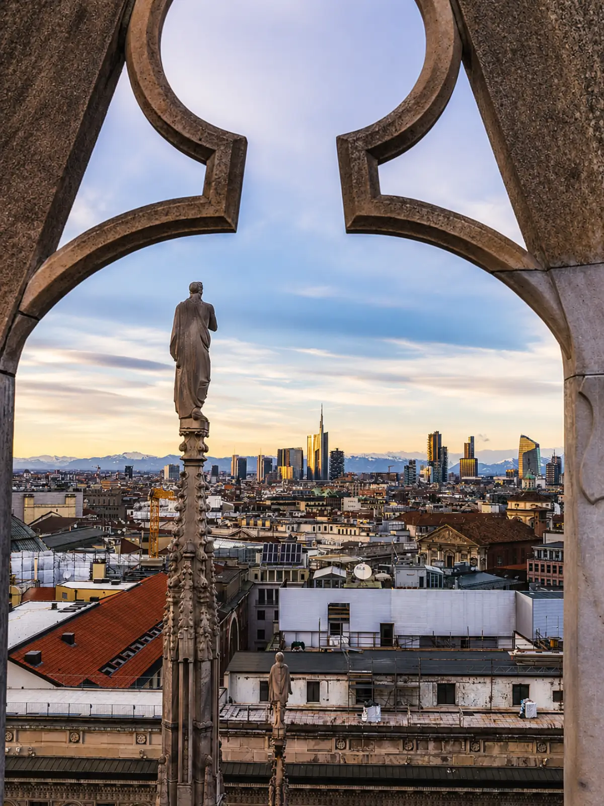 City skyline viewed from the rooftop of Milan Cathedral at sunset.
