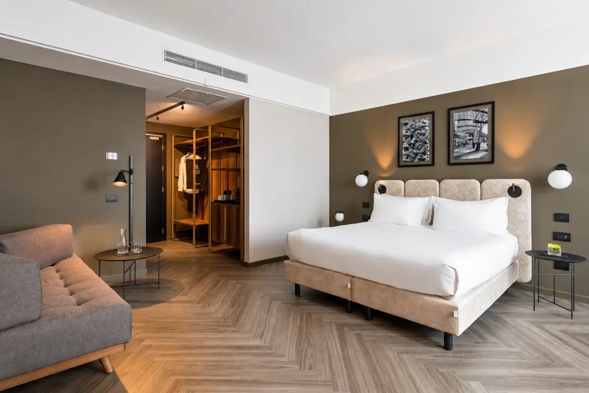 Hotel Tocq room with a modern bed, sofa, and warm neutral interiors.