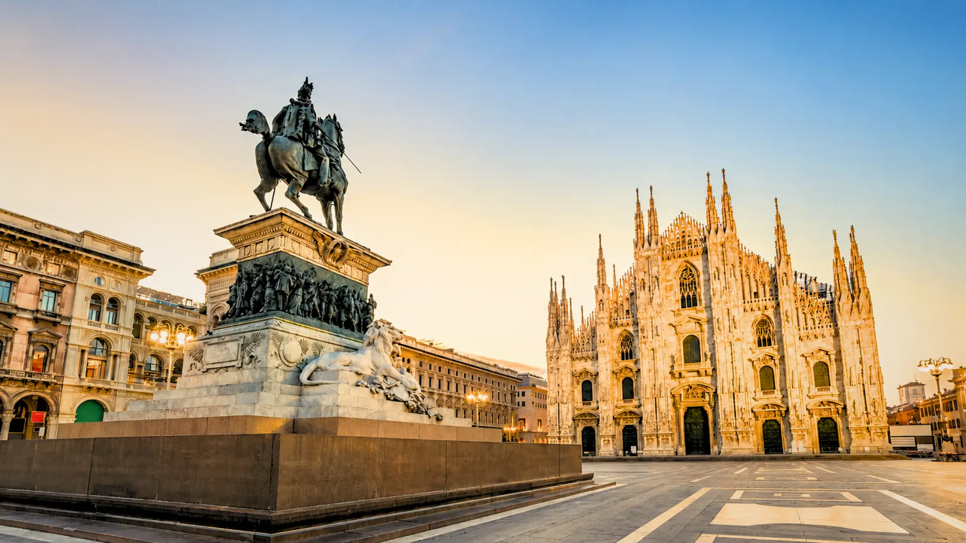 View of Milan Duomo and the Vittorio Emanuele II statue in Piazza del Duomo at sunrise.