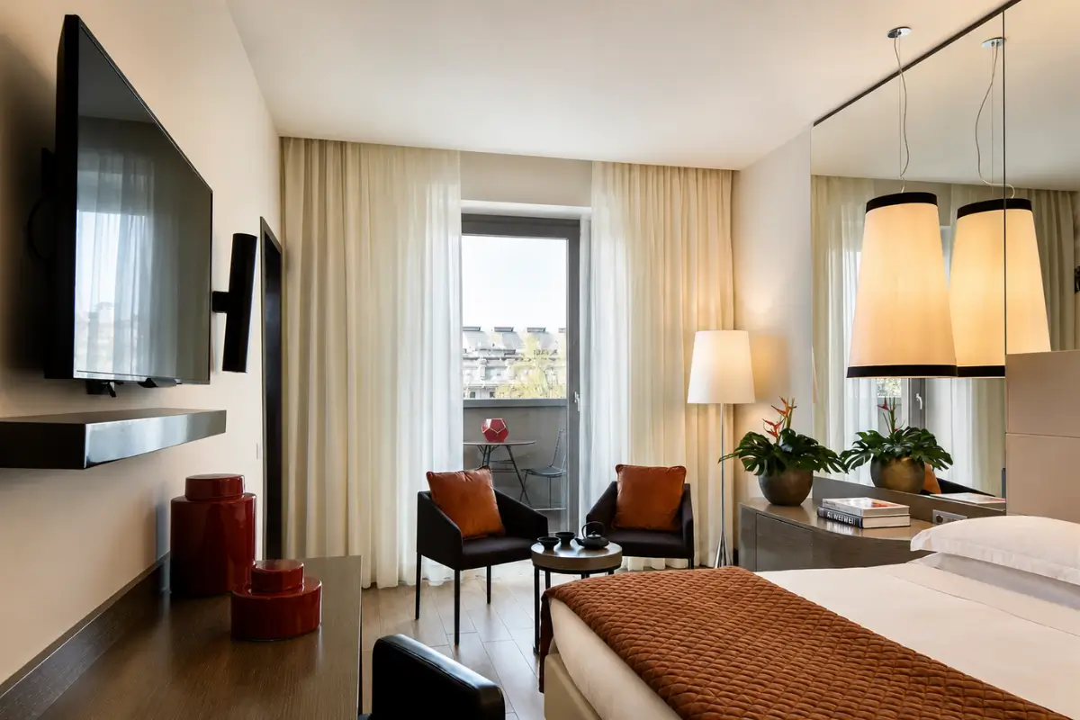 Modern room interior at Starhotels E.c.ho. Milano with warm neutral décor and large windows.