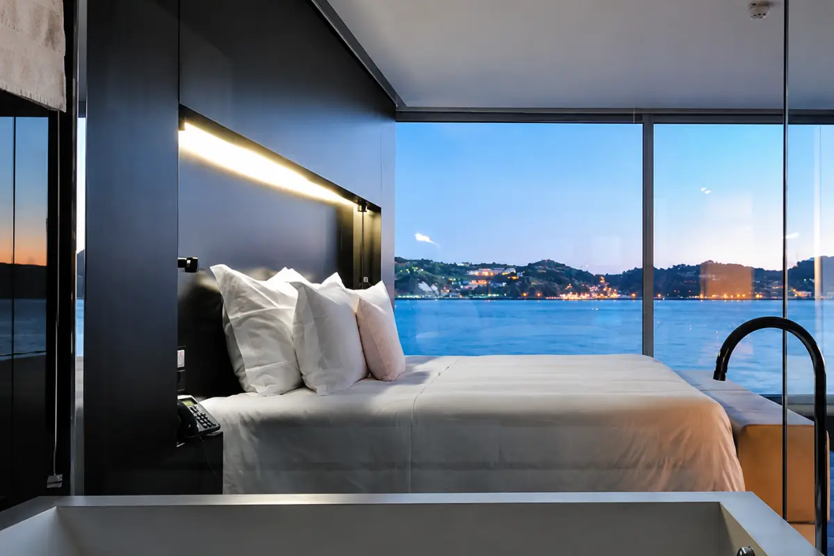 Modern room at Altis Belém Hotel & Spa with a bed overlooking the waterfront.
