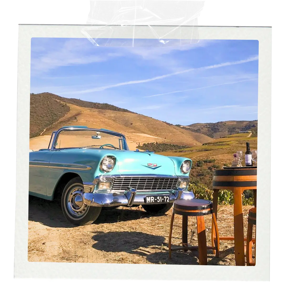 Vintage car beside terraced vineyards in the Douro Valley.