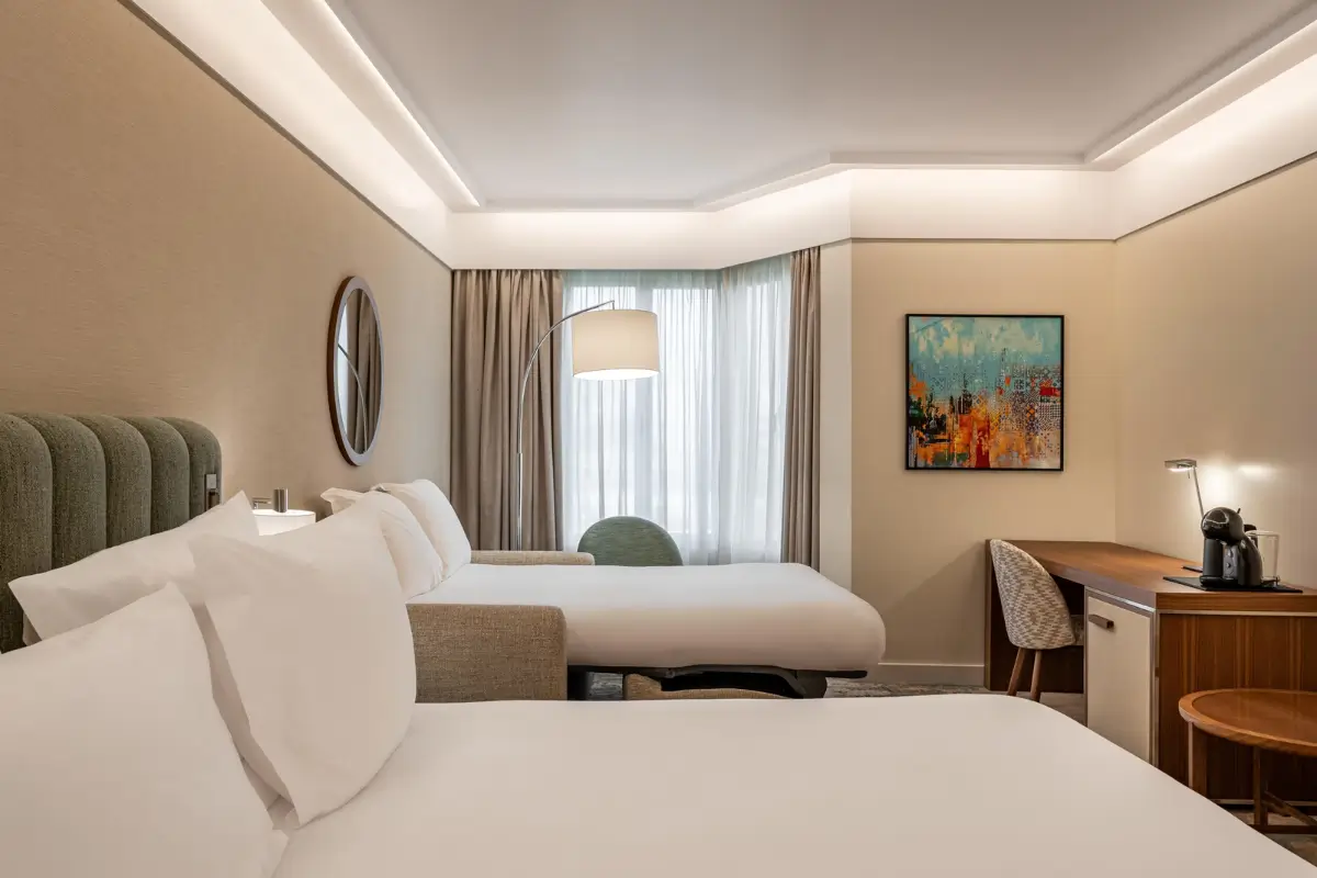 Renovated room at Crowne Plaza Porto with twin beds, a work desk and modern neutral furnishings.