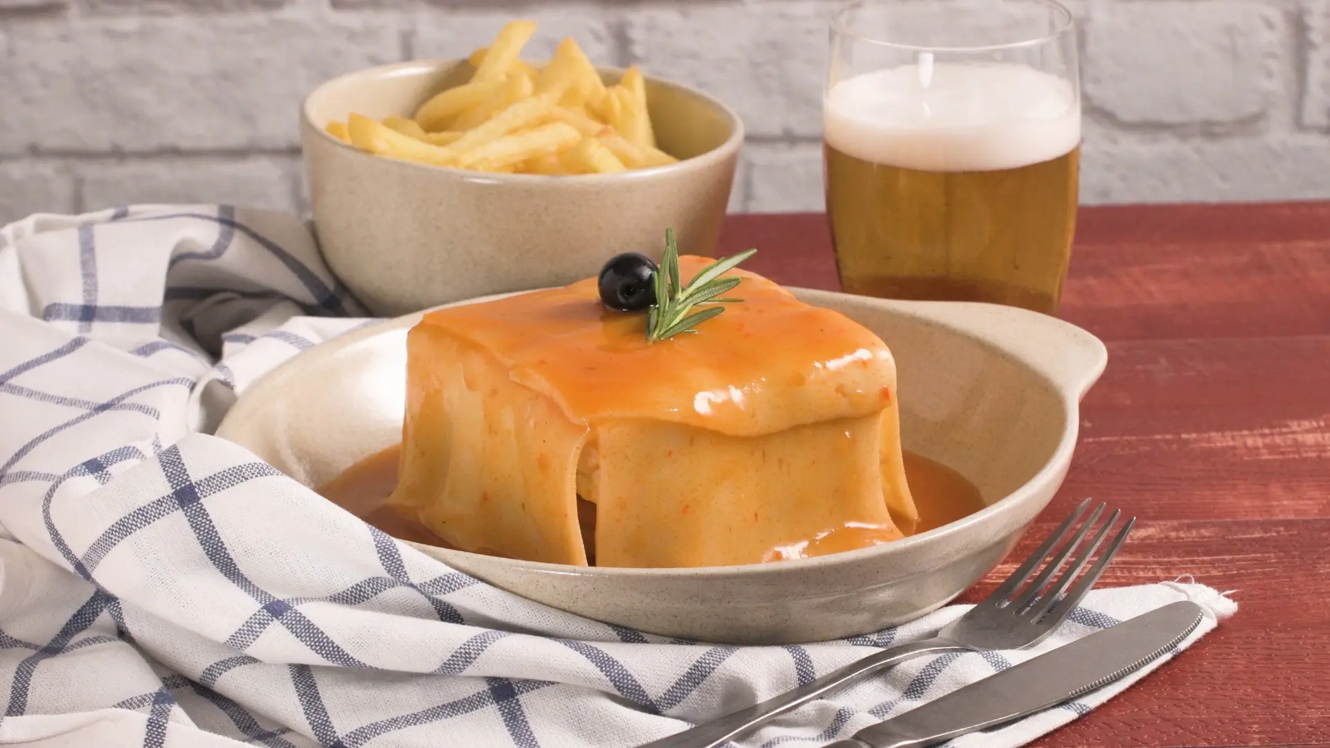 Francesinha served with chips and beer in Porto, Portugal.