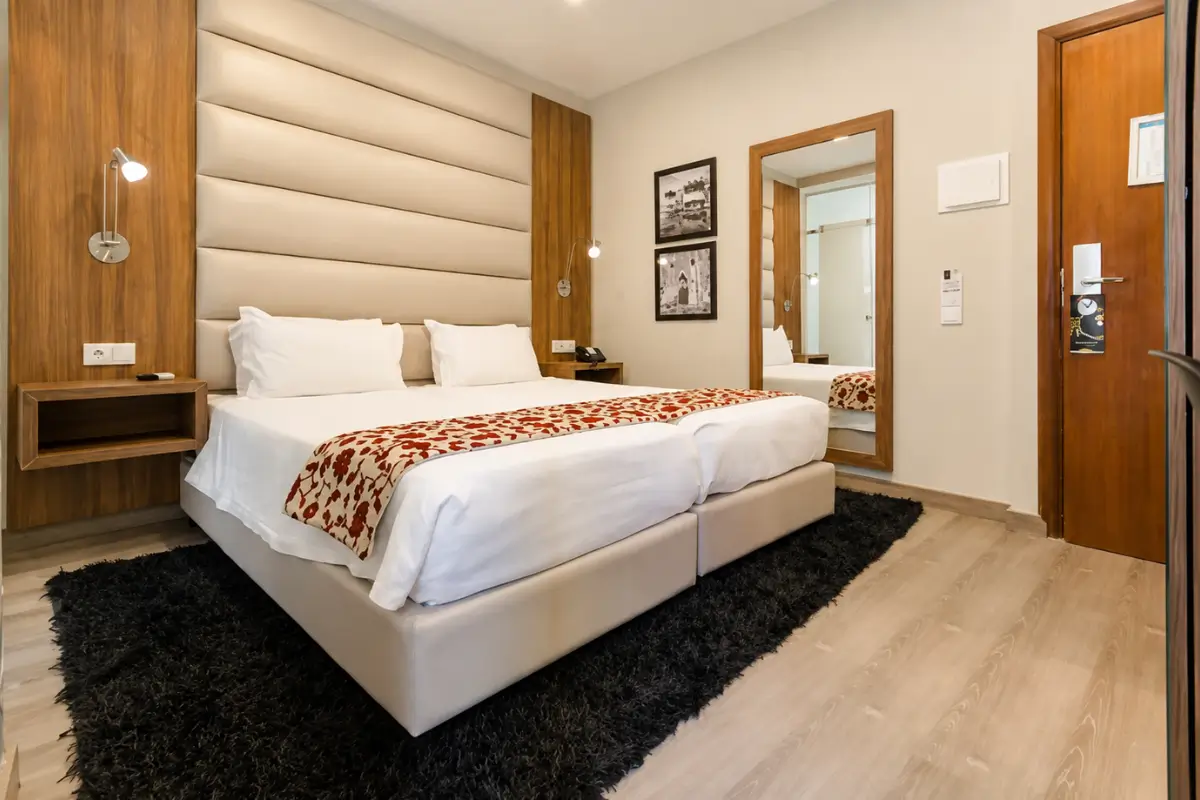 Hotel Borges Chiado room with a double bed and modern wood furnishings.