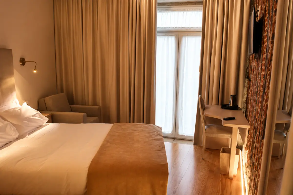 Warmly lit room at Muralha Charm House in Lamego with an exposed stone wall.