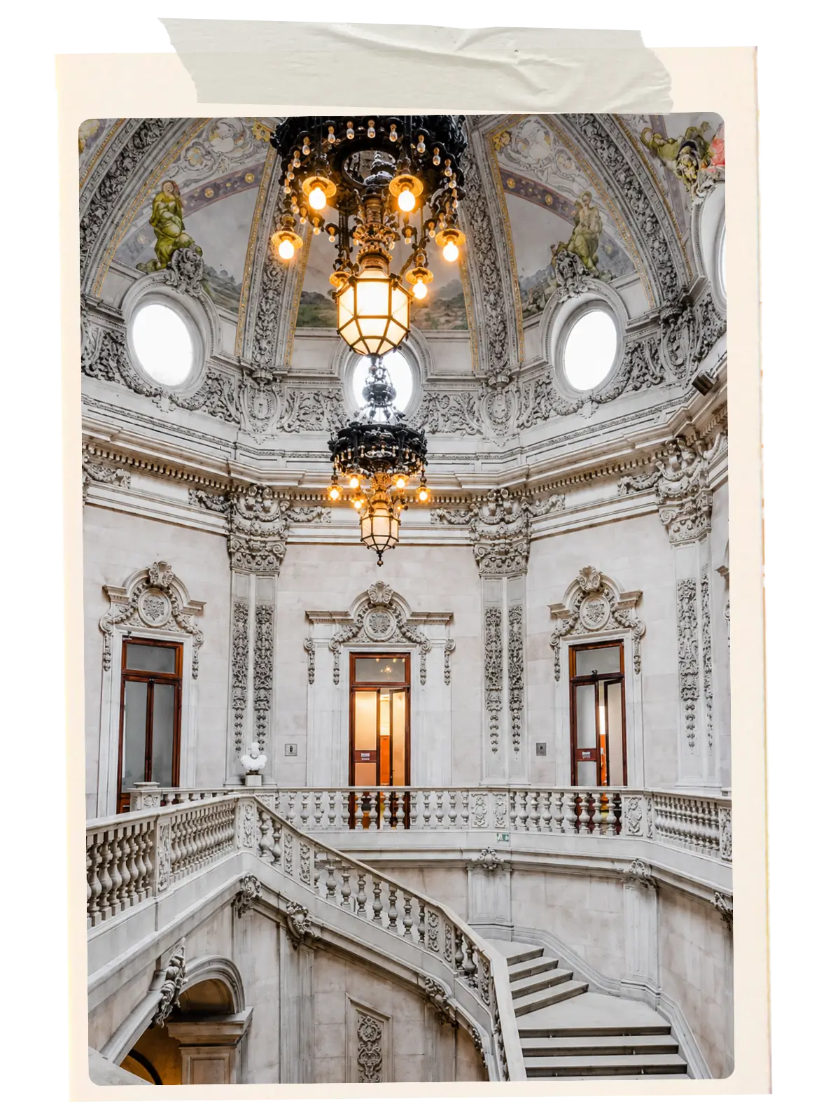 Ornate staircase and chandeliers inside Palácio da Bolsa.