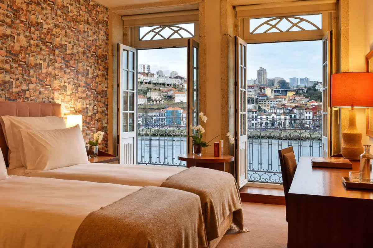 Twin room at Pestana Vintage Porto with balcony doors overlooking the Douro and Vila Nova de Gaia.