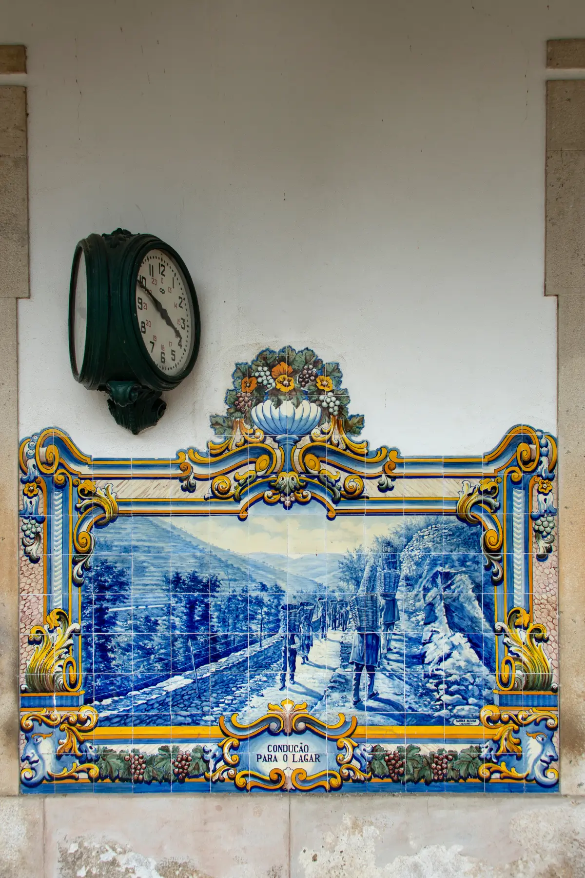 Blue-and-white azulejo panel depicting vineyard workers at Pinhão Railway Station.