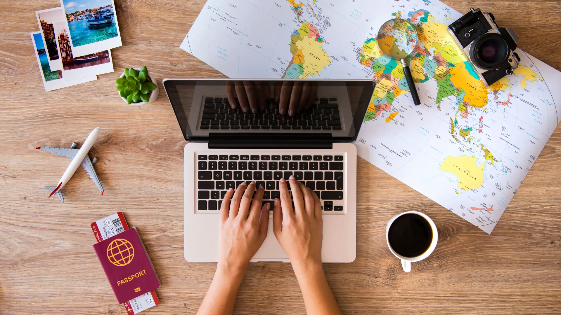 Planning a multi-city trip with a laptop, world map, passport, and travel photos.