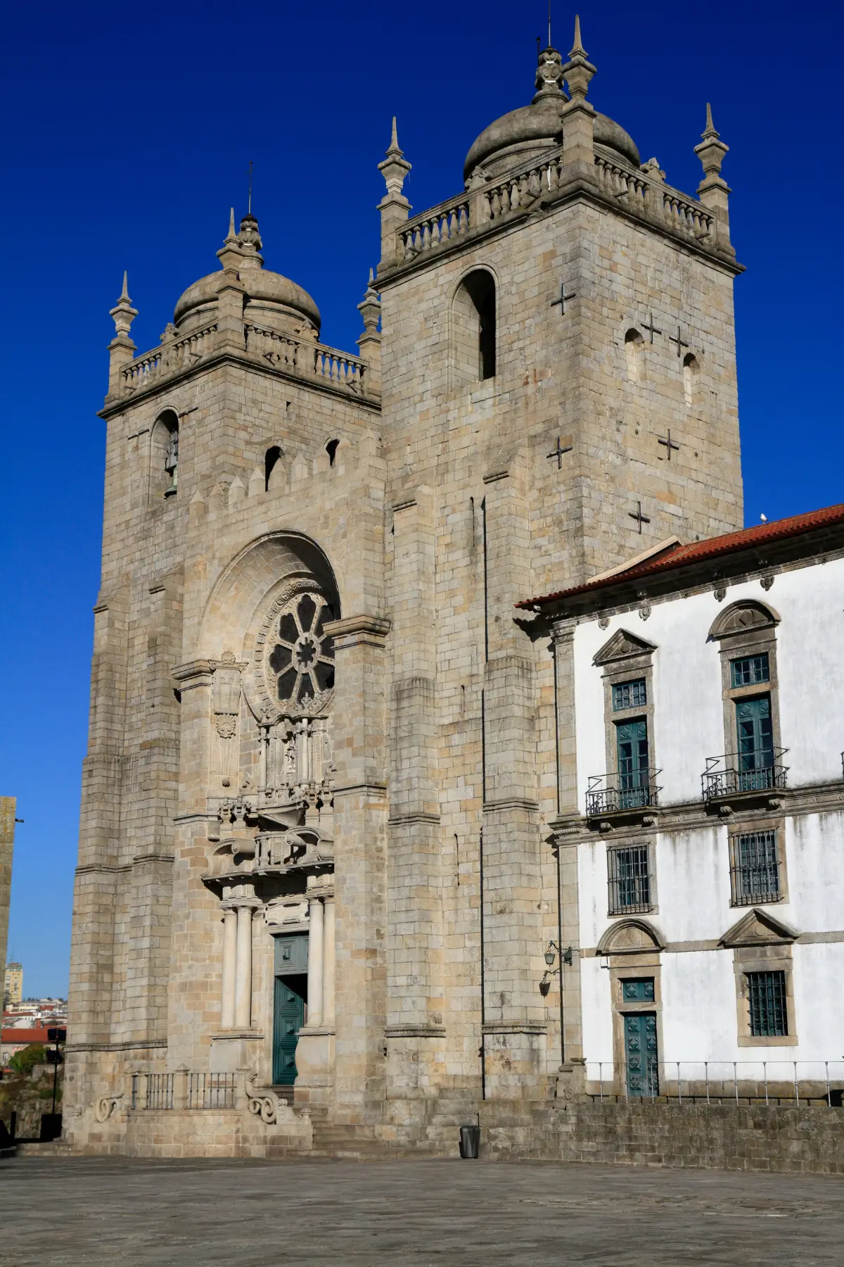 Porto Cathedral with its twin stone towers against a deep blue sky.