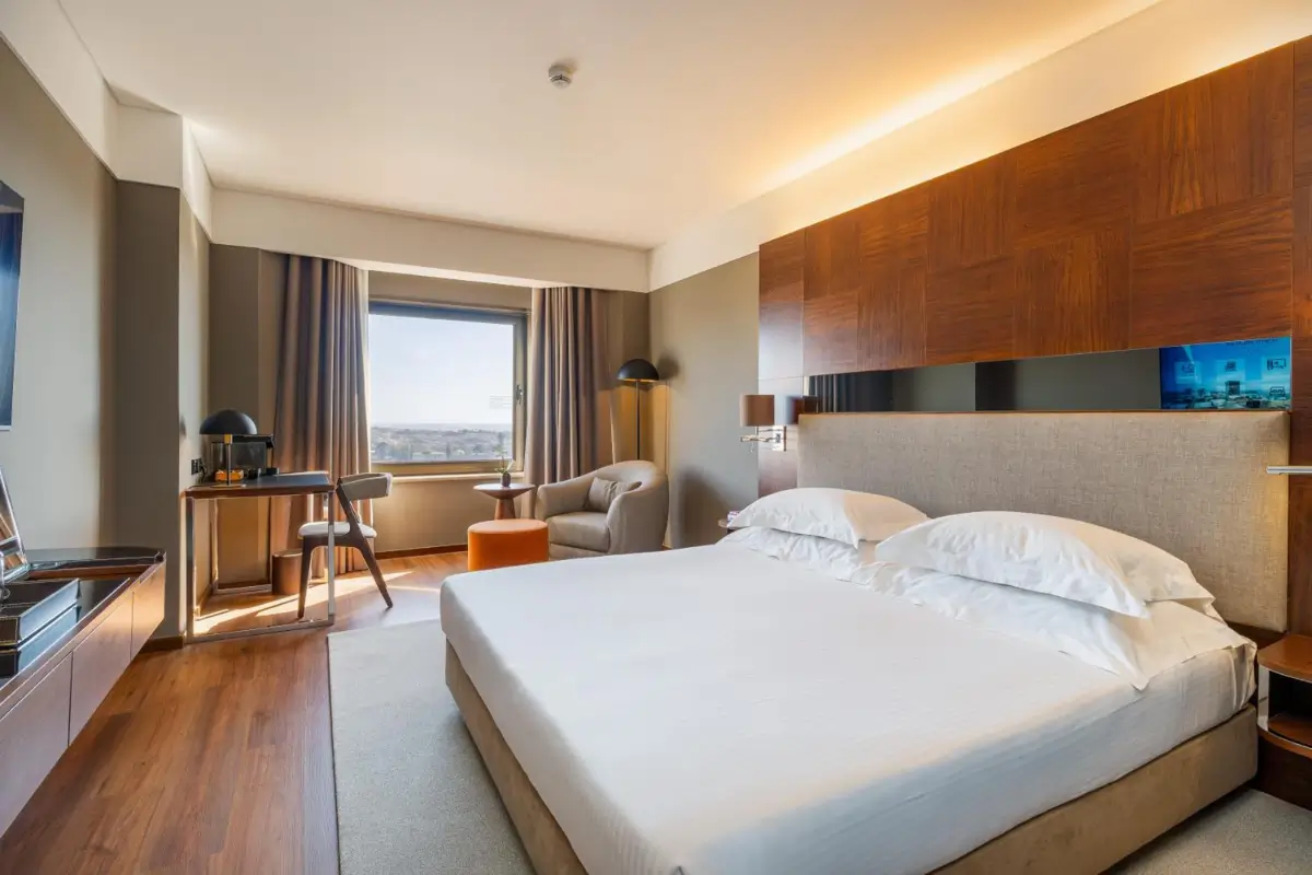 Modern room at Porto Palácio Hotel by The Editory with a large bed, wood furnishings and city views.