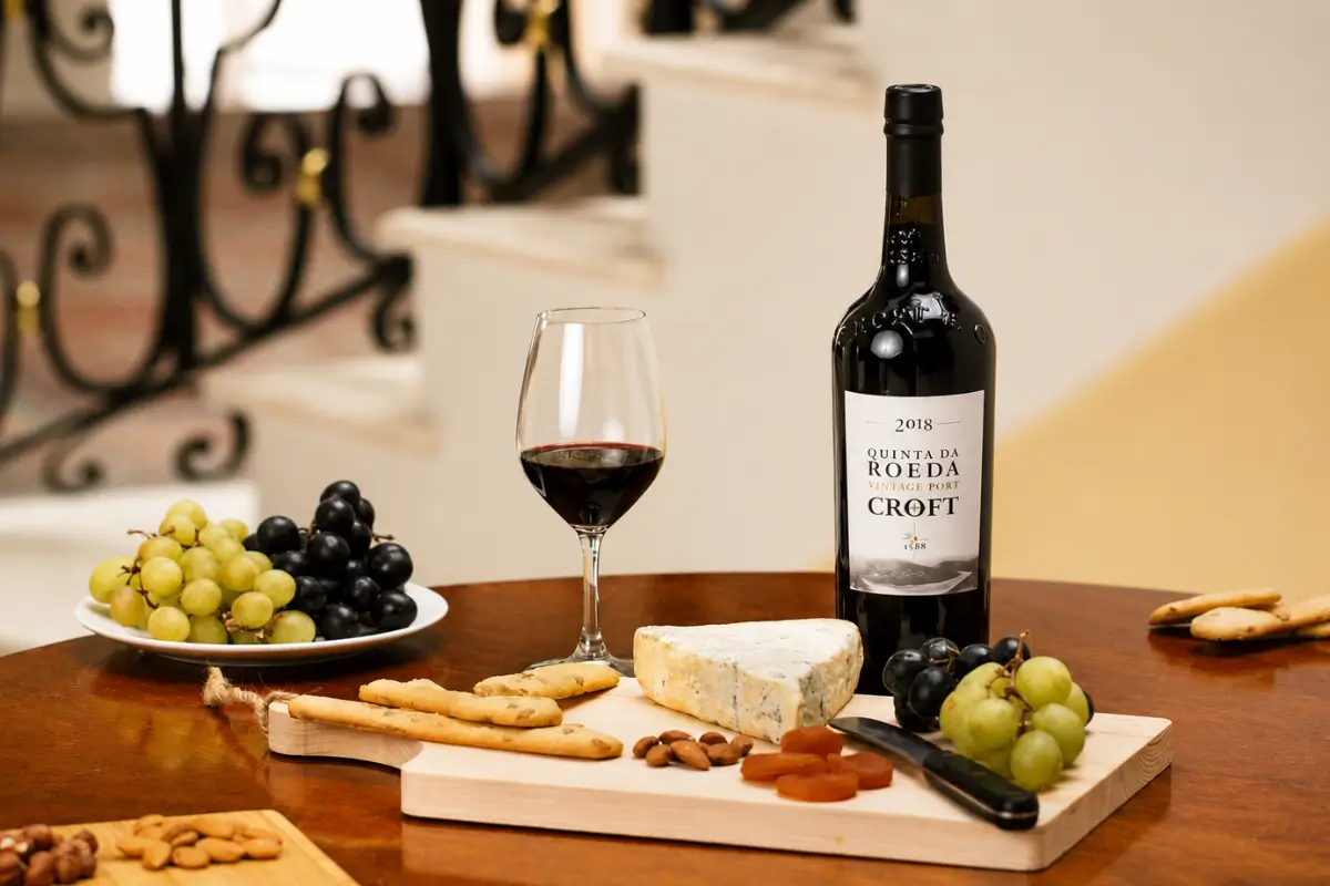 Quinta da Roêda Vintage Port with a glass of wine, grapes and cheese.