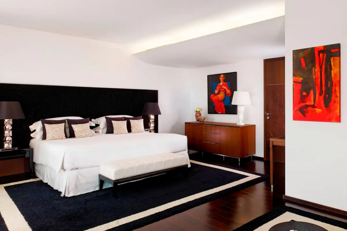 Spacious room at Sheraton Porto Hotel & Spa with a large bed, dark wood furnishings and contemporary artwork.