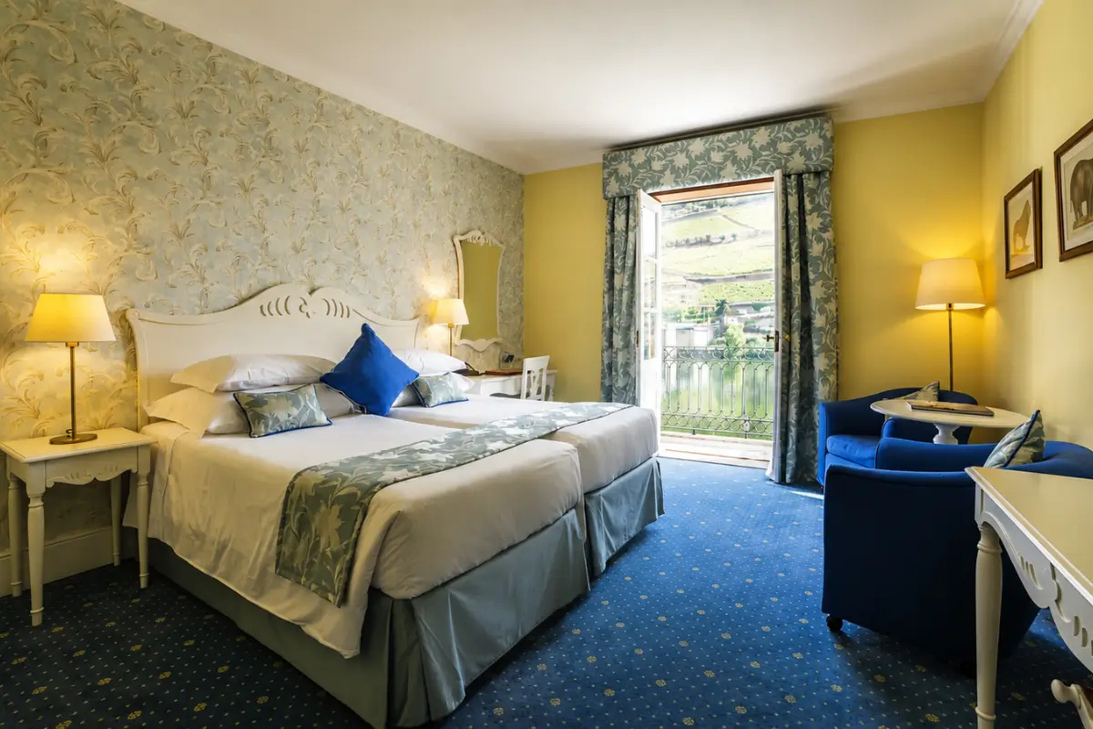 Guest room at The Vintage House Douro overlooking the surrounding vineyard hills.