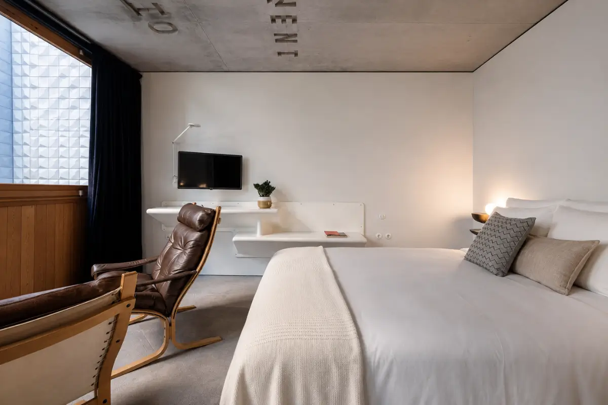 Modern guest room at Tipografia do Conto in Porto with a minimalist bed.