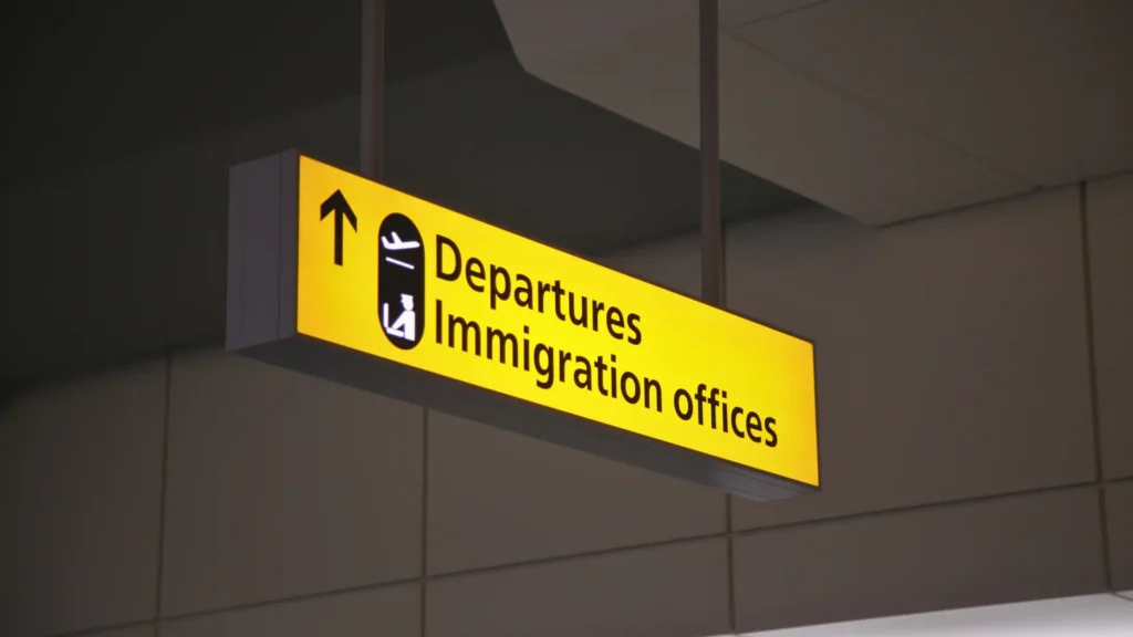 Airport sign for departures and immigration offices.