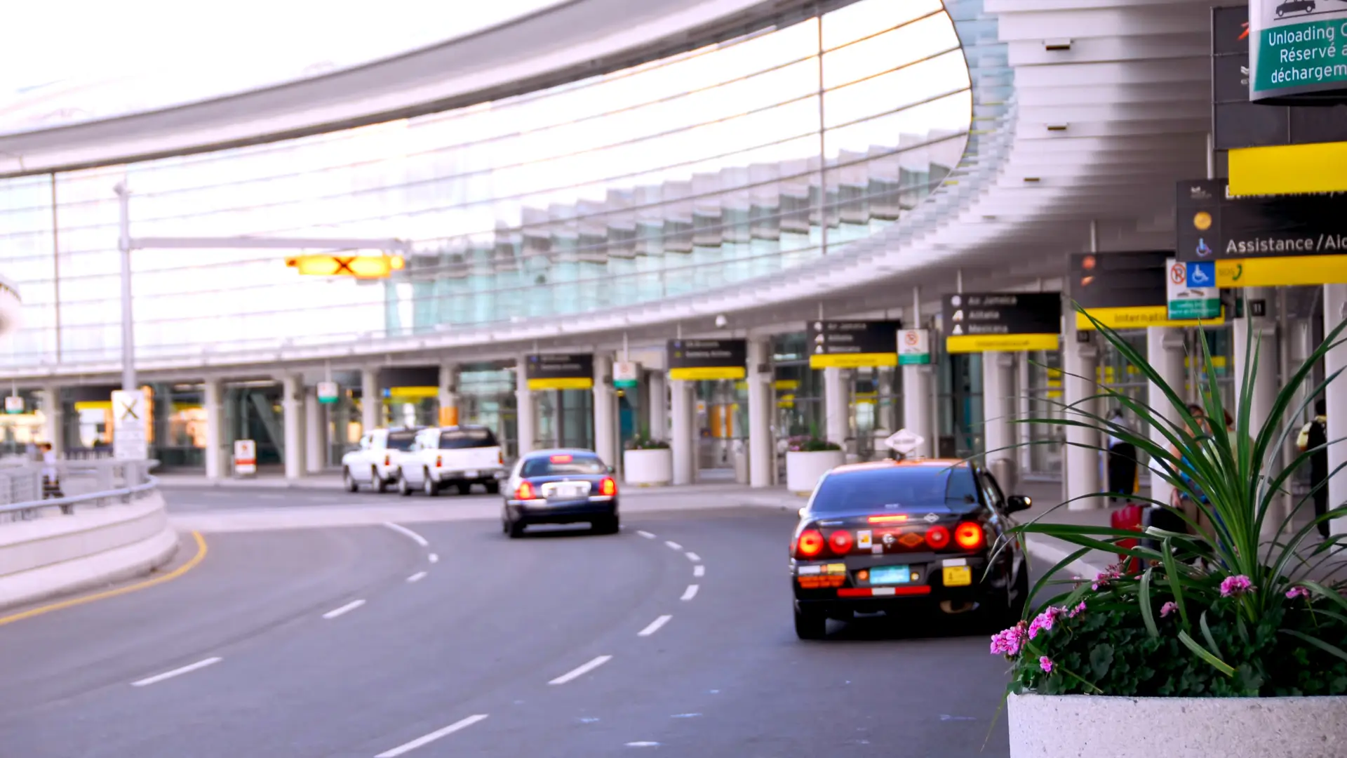 Taxis waiting outside an airport terminal.