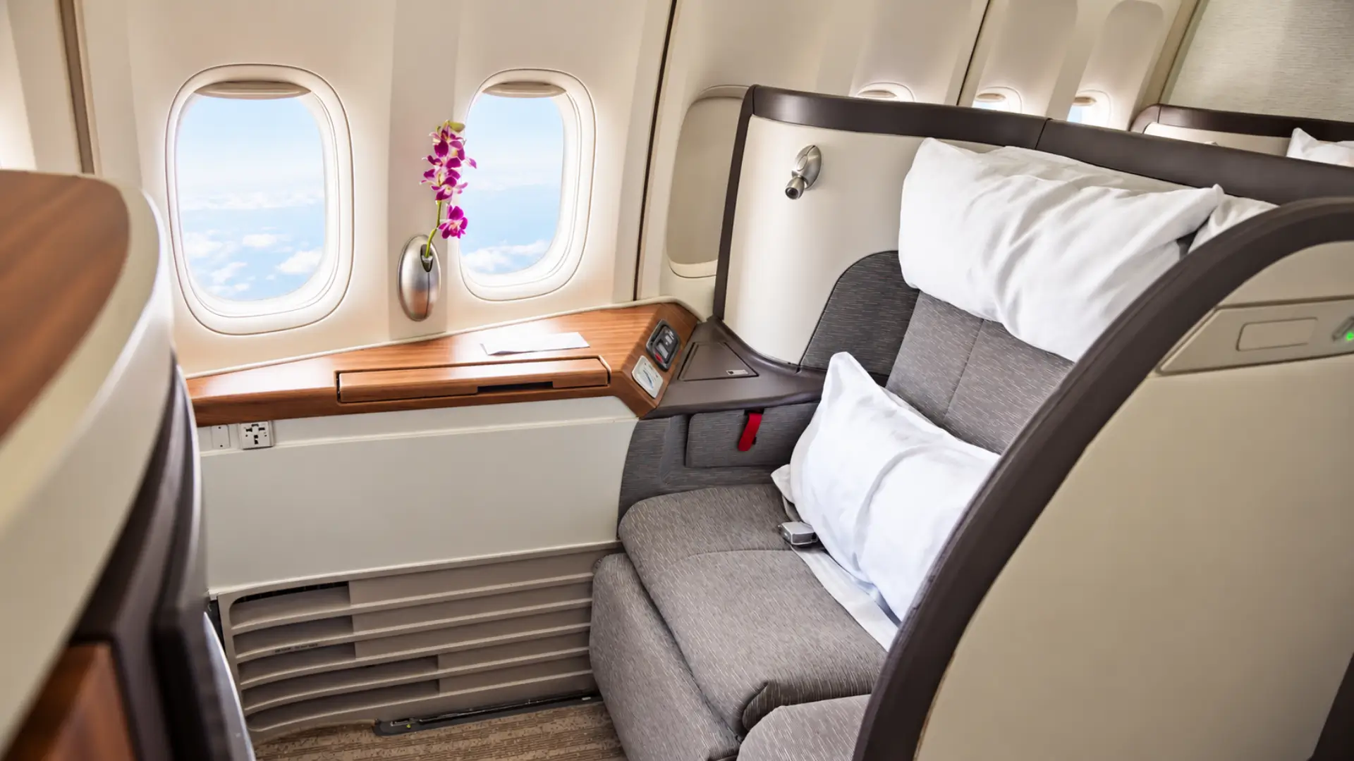 Business class window seat with extra space on a plane.