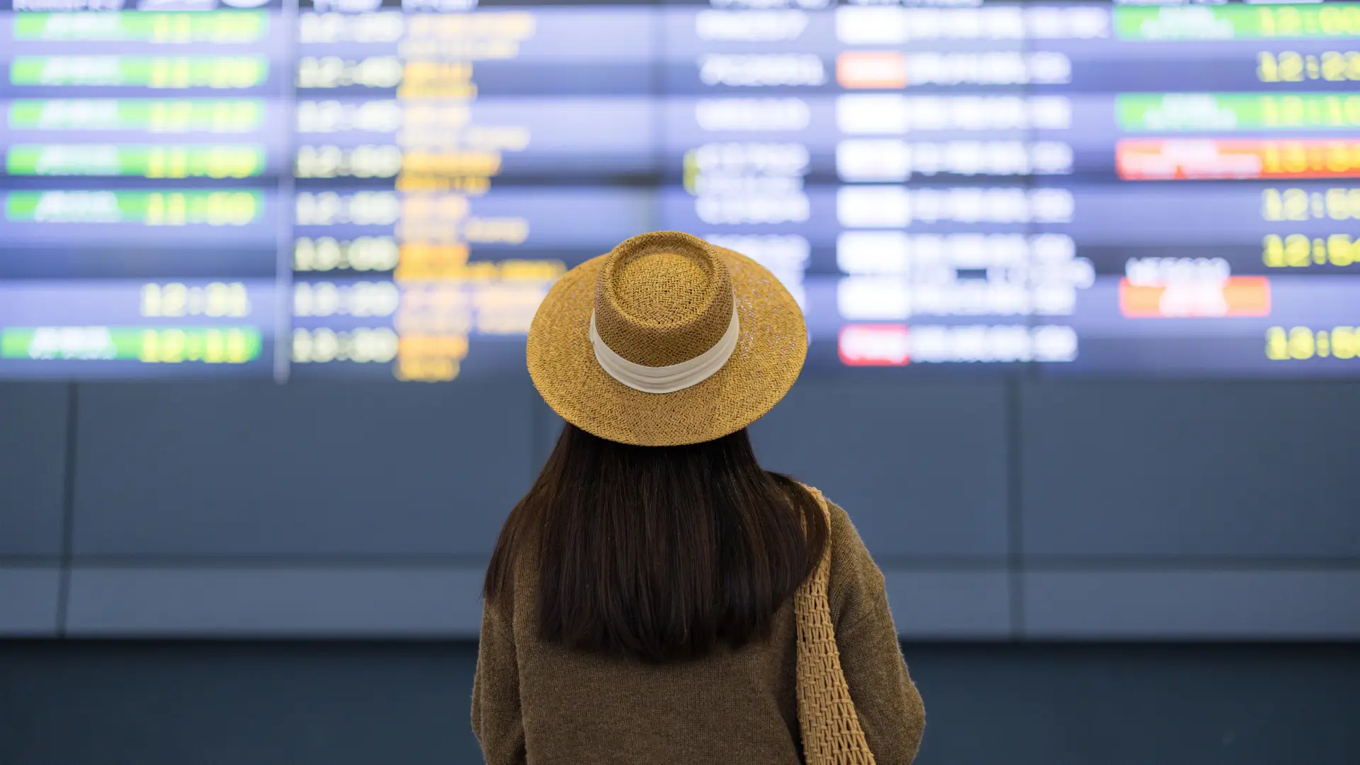 Traveller checking the departures board at an airport.